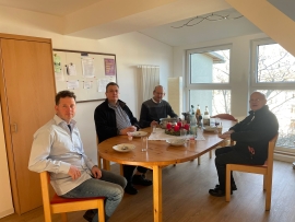 Vier Ordensleute sitzen um einen Tisch