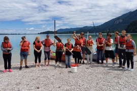 Jugendgruppe mit Paddeln und Schwimmwesten am See